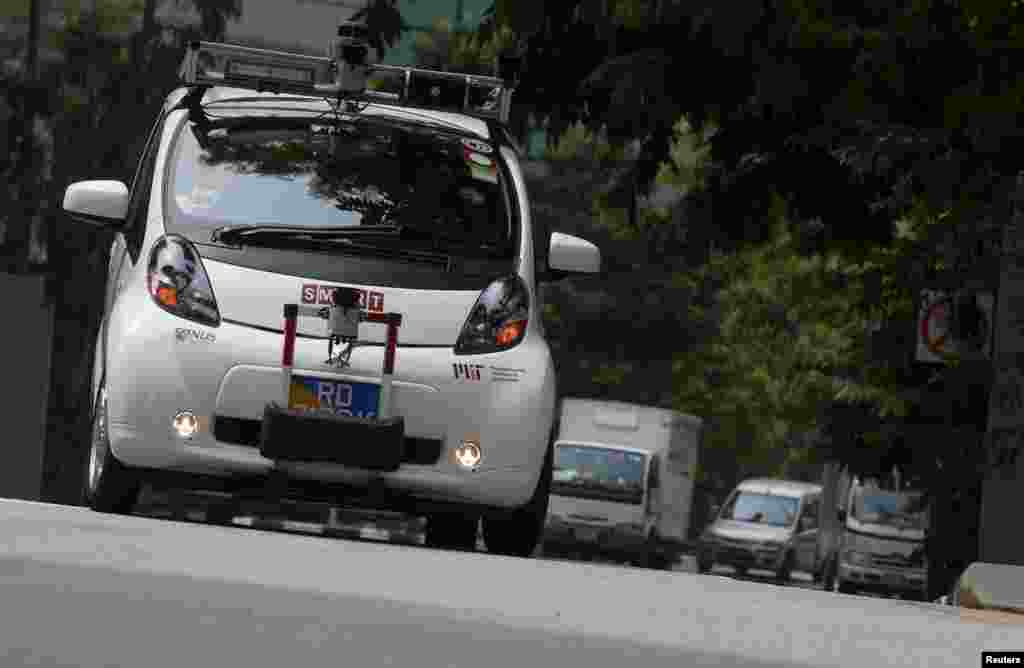 An autonomous self-driving vehicle goes onto the road during a demonstration at one-north business park in Singapore. Singapore unveiled its public transport future, and it was a vision of passengers commuting in driverless buses along roads and freeways populated by platoons of autonomous trucks following a single driver.