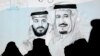 Peserta Saudi di Future Investment Initiative, "FII" di depan layar yang menampilkan gambar Raja Saudi Salman, kanan, dan Putra Mahkota Mohammed bin Salman. (Foto: AP)