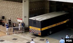 有声援唐英杰的市民质疑当局安排多部囚车出入高等法院，企图误导支持者，不能送别押解唐英杰到监狱的囚车（美国之音/汤惠芸）