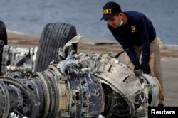 Penyelidik Komisi Nasional Keselamatan Transportasi (KNKT) memerikan mesin pesawat Lion Air JT610 di pelabuhan Tanjung Priok, 4 November 2018.