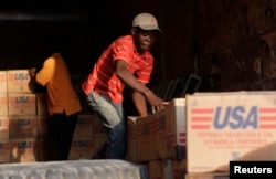 Americans donated more than $1.4 billion to nearby Haiti after a devastating earthquake in January 2010. Here, men stack supplies in Port-au-Prince on March 17, 2010.