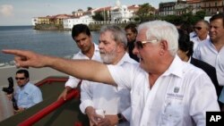 El presidente de Panamá Ricardo Martinelli (derecha) muestra al expresidente de Brasil Luiz Inacio Lula da Silva (segundo desde la derecha) una parte de franja costera construída por la compañía brasileña Odebrecht en la Ciudad de Panama, el 20 de mayo de 2011.