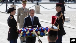 French President Francois Hollande, center, lays a wreath at the Tomb of the Unknown Soldier during commemorations at the Arc de Triomphe marking the 71st anniversary of the end of World War II, in Paris, May 8, 2016. 