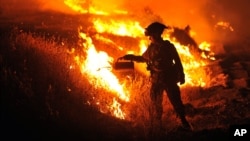 California firefighter Bo Santiago watches a backfire as the Rocky fire burns near Clearlake, California, Aug. 3, 2015.