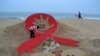 Seniman India menghias pantai Puri dengan hiasan pita merah pada Peringatan Hari AIDS Sedunia dekat Bhubaneswar, India timur (foto: ilustrasi). 