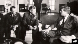 President John F. Kennedy meet with military officers to discuss the U-2 spy plan over Cuba.