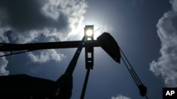 FILE - Oil is pumped from a well near Van, Texas.