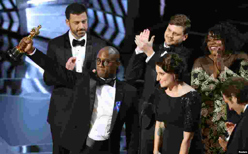 Sutradara dan penulis Barry Jenkins memegang piala Oscar untuk film terbaik bagi &quot;Moonlight&quot;, didampingi oleh para aktor dan aktris film itu.