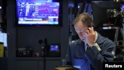 Traders work on the floor at the New York Stock Exchange (NYSE) in New York, U.S., May 14, 2019. 