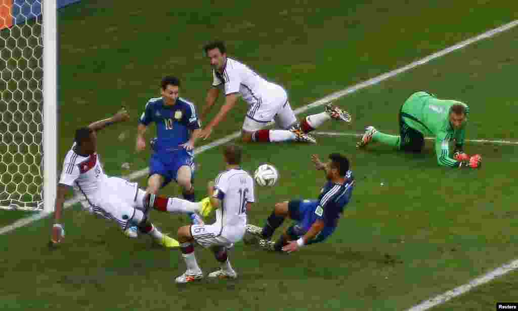 Germany's Jerome Boateng clears the ball past Argentina's Ezequiel Lavezzi and Lionel Messi at the Maracana stadium in Rio de Janeiro, July 13, 2014.