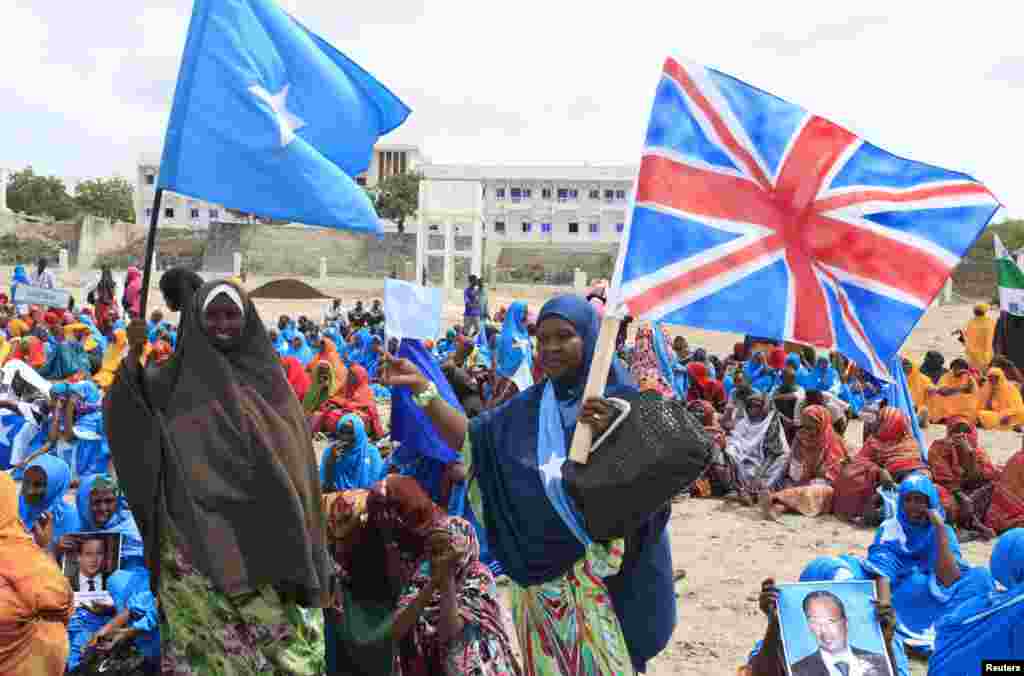 Residents carry the flags of Britain and Somalia as they take part in a parade in support of the Somalia conference in London, along the streets of Somalia's capital Mogadishu, May 7, 2013. 