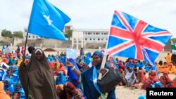 Wasomalia wakipeperusha bendera za Somalia na Uingereza wakati wa maandamano kuunga mkono mazungumzo ya London