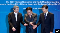 South Korea's Trade, Industry and Energy Minister Yoon Sang-jick, center, tries to hold hands to pose for the media with Japan's Economy, Trade and Industry Minister Motoo Hayashi, left, and China International Trade Representative Zhong Shan before the 1