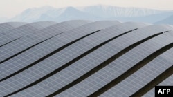 FILE - Solar panels are seen at the Les Mees solar power plant in Les Mees, southern France. Japan's new financing plan is an increase from its current assistance of about 1 trillion yen ($8.2 billion).