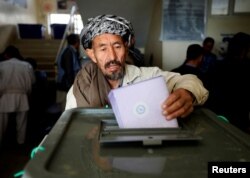 FILE - An Afghan man casts his vote during the parliamentary election at a polling station in Kabul, Oct. 21, 2018.