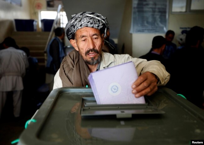 FILE - An Afghan man casts his vote during the parliamentary election at a polling station in Kabul, Oct. 21, 2018.