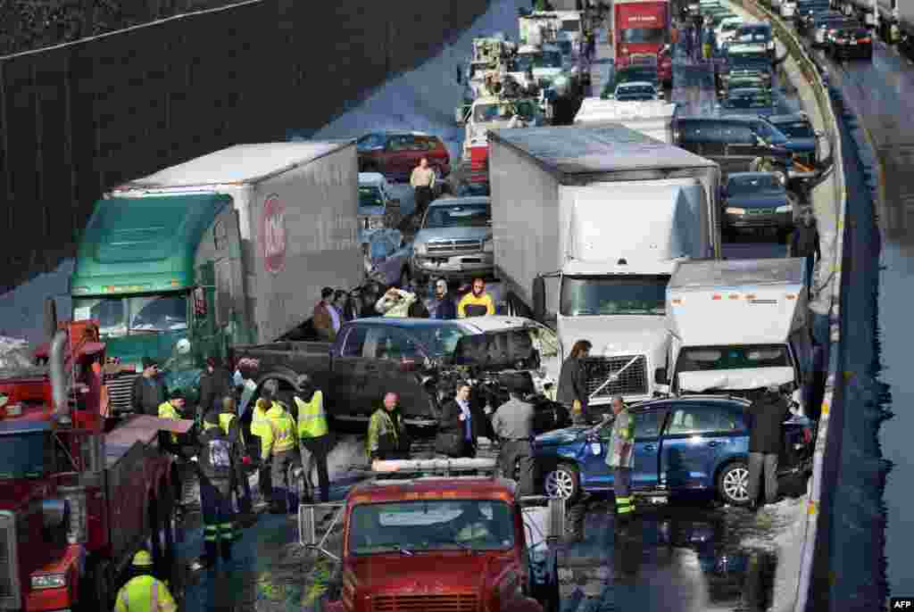 Rescue and fire personnel assist on the scene of a 100-car chain reaction pileup accident on the Pennsylvania Turnpike eastbound in Feasterville. Icy weather conditions contributed to the accident. It is expected to take hours to remove all of the debris from the massive crash scene, which stretches for miles.