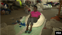 Lilian Wairimu sits on a beanbag she made for a client. It takes at least six days to make each item. (M. Yusuf/VOA)