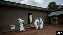 Wafanyakazi wa afya wakibeba mtu aliyefariki kutokana na Ebola katika mji wa Mangina, karibu na Beni, DRC. August 22 2018 PICHA: AFP