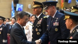 20일 한국 합참의장 이취임식 행사가 열린 국방부 청사에서 존 하이텐 미 전략사령관(오른쪽)과 문재인 한국 대통령이 악수하고 있다. 