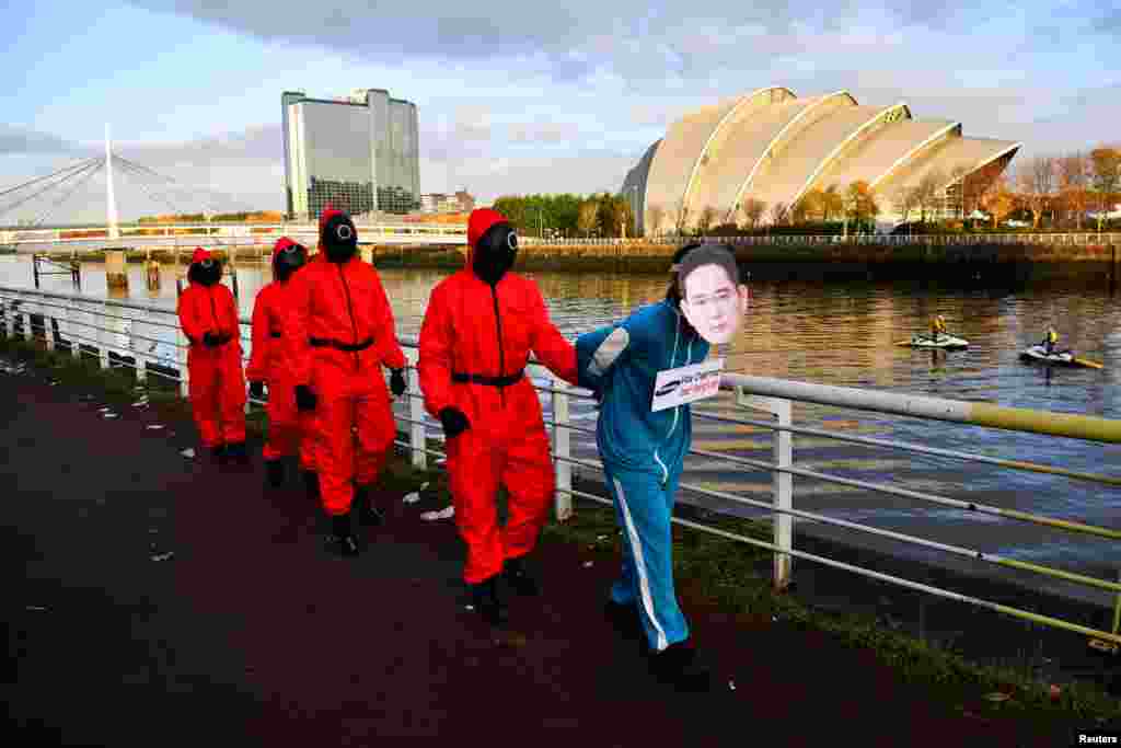 Climate activists dressed as characters inspired by the Netflix series &quot;Squid Game&quot; protest as they ask Samsung to go 100% renewable energy, outside the venue for the U.N. Climate Change Conference (COP26) in Glasgow, Scotland.