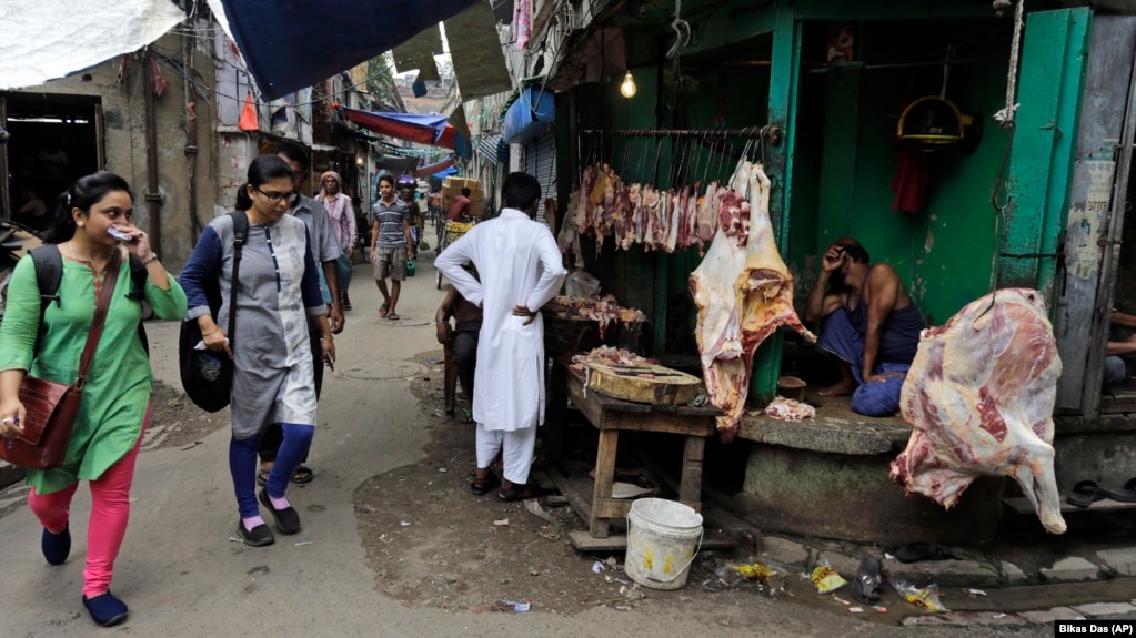 People walk past a shop selling cow meat in Kolkata, capital of the eastern Indian state of West Bengal.