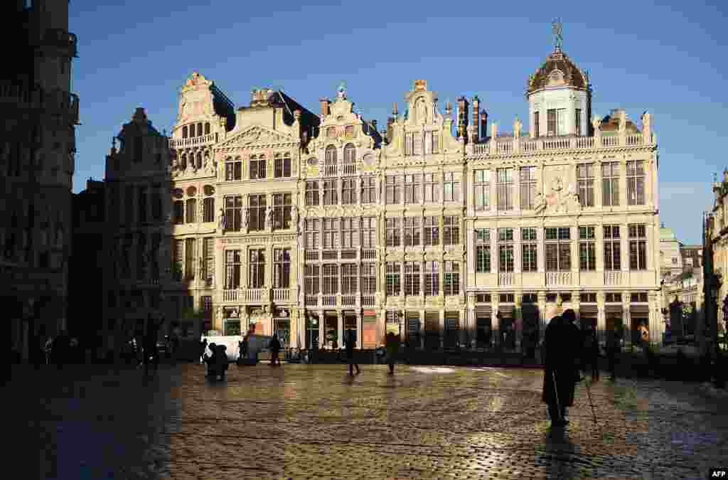 People walk at an almost empty Grand Place central square in Brussels, Nov. 23, 2015.
