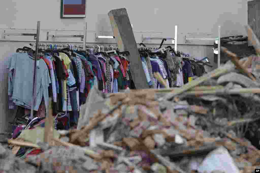Baju-baju yang digantung di lokasi gedung runtuh di Philadelphia, Pennsylvania (6/6), yang menimpa toko barang bekas. (AP/Matt Rourke)