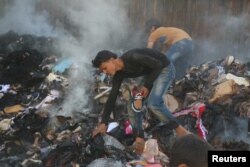 People salvage goods from an aid convoy that was damaged during an airstrike in the rebel held area of al-Sakhour district of Aleppo, Syria, June 4, 2016.