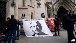 Sebuah spanduk yang bertuliskan dukungan terhadap pendiri WikiLeaks Julian Assange dipasang di luar gedung Pengadilan Tinggi London, pada 23 Oktober 2021. Spanduk tersebut dibentangkan menjelang pengadilan kasus ekstradisi Assange. (Foto: AP/Alberto Pezzali)