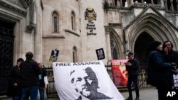 Plakat u znak podrške osnivaču Vikiliksa Džulijanu Asanžu ispred Kraljevskog suda pravde u Londonu, 23. oktobru 2021. 