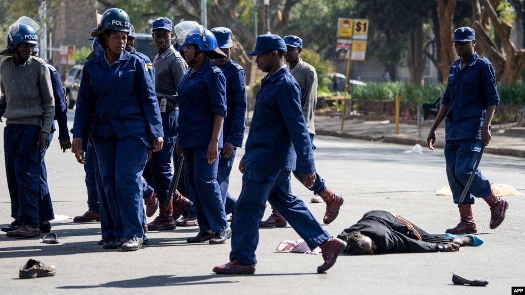 FILE: A protester lies unconsciously on the ground after being beaten by police near Unity Square in Harare on August 16, 2019. 