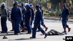 FILE: A protester lies unconsciously on the ground after being beaten by police near Unity Square in Harare on August 16, 2019. 