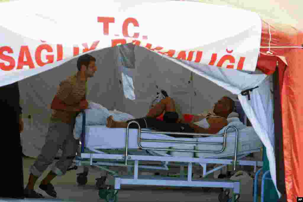 A wounded Syrian refugee talks with another in a camp near the Turkish border town of Yayladagi in Hatay province on June 27, 2011 (AFP)