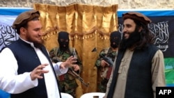 Ehsanullah Ehsan, kiri, pada saat menjadi juru bicara Tehreek-e-Taliban Pakistan, berbicara dengan anggota baru TTP Adnan Rasheed setelah konferensi pers di Shabtoi, sebuah desa di Waziristan Selatan, di Pakistan, 2 Februari 2013. 