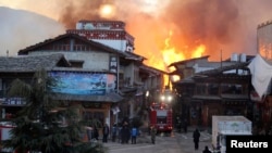 Fire blazes at the Dukezong Ancient Town in Shangri-la county, Yunnan province on Jan. 11, 2014. 