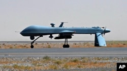 FILE - A U.S. Predator unmanned drone armed with a missile stands on the tarmac of Kandahar military airport in Afghanistan, June 13, 2010.