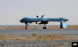 FILE - In this June 13, 2010, file photo a U.S. Predator unmanned drone armed with a missile stands on the tarmac of Kandahar military airport in Afghanistan.