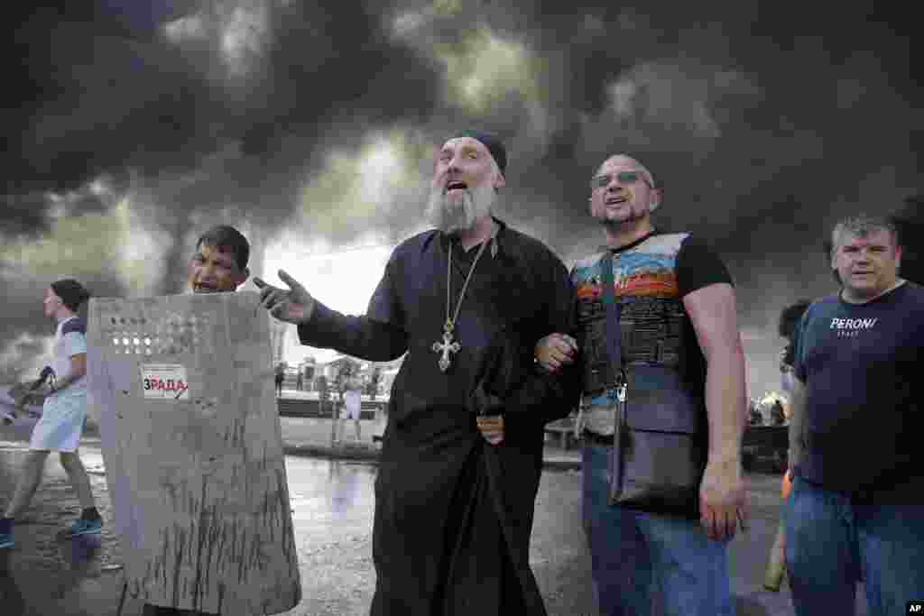 Activists shout during clashes with forces from the Kyiv-1 volunteer battalion on Independence Square in Kyiv, Ukraine. Demonstrators confronted city workers attempting to clear the central square, lighting tires on fire in protest against the city government&#39;s move.