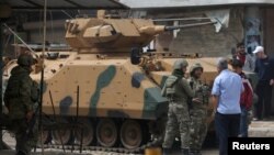 People speak with Turkish soldiers in the center of Afrin, Syria March 24, 2018. 