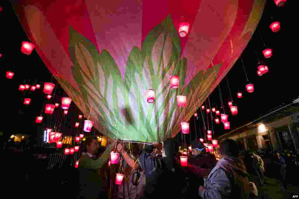 People raise balloons during the second day of the International Cantoya Festival in Patzcuaro, Michoacan State, Mexico.