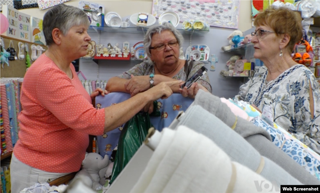 Mary Lee Nielson, con clientes en su negocio, el techo acolchado en Valley City, Dakota del Norte, también copropietario de una granja familiar.  Dijo que debido a las crecientes tarifas entre EE. UU. Y China, "es una situación muy aterradora en este momento ... Puedo ver que muchos agricultores no quieren gastar su dinero".