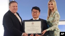 Kim Jong-chul, center, from South Korea, receives an award from Secretary of State Mike Pompeo, left, and Ivanka Trump, right, the daughter and assistant to President Donald Trump, during an event to announce the 2018 Trafficking in Persons Report.