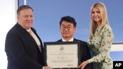 Kim Jong-chul, center, from South Korea, receives an award from Secretary of State Mike Pompeo, left, and Ivanka Trump. (June 28, 2018.)
