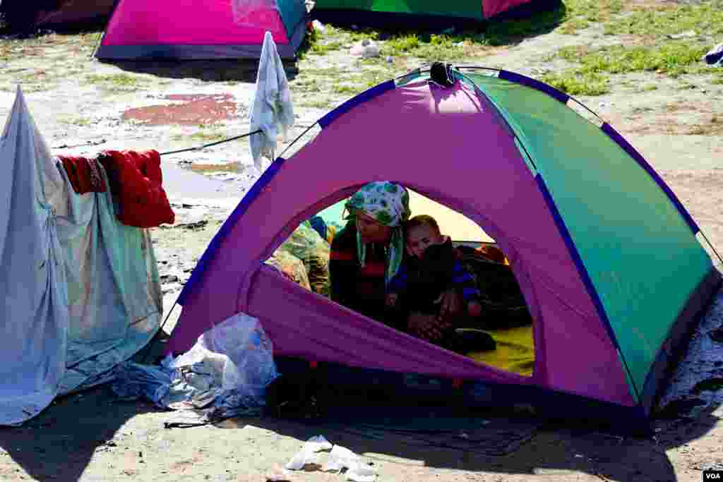 A woman and child huddle in a tent in a makeshift encampment in Idomeni, Greece, waiting for permission to move onto other points in Europe, March 4, 2016. 