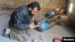 FILE - A Free Syrian Army fighter prepares a locally made shell before firing it toward forces loyal to Syria President Bashar al-Assad in Bani Zeid neighborhood, Aleppo, Nov. 10, 2014. 