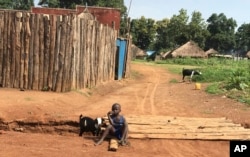 FILE - A young boy sits on the road in the town of Yei on July 13. 2017, one of the few remaining residents in a city riddled with murder, rape and abductions.