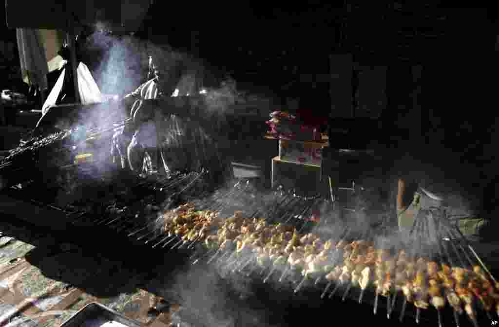 A Palestinian vendor grills meat as he waits for customers before Iftar during the Muslim holy month of Ramadan,West Bank town of Jenin, July 30, 2013.&nbsp;