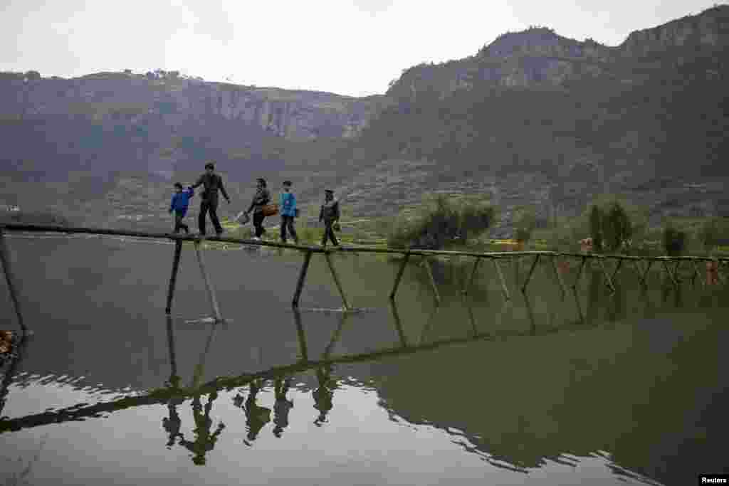 Người d&acirc;n địa phương băng qua cầu tới đồn điền trồng tr&agrave; ở huyện T&acirc;n Xương, tỉnh Chiết Giang, Trung Quốc.
