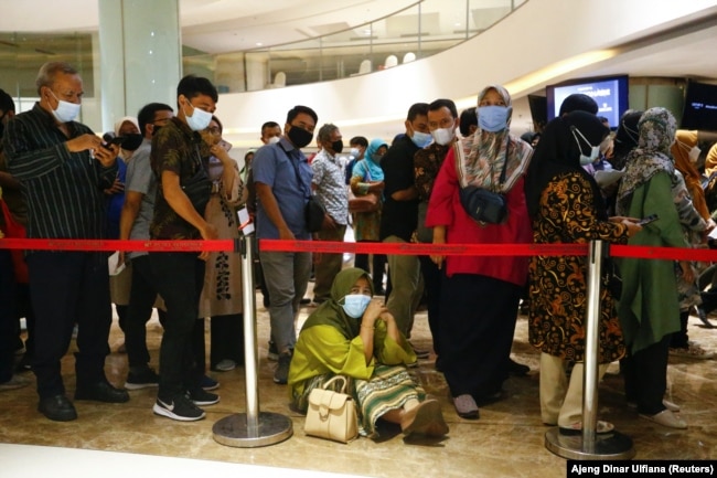 Seorang perempuan duduk di lantai saat dia mengantre untuk menerima dosis vaksin Sinovac China di sebuah pusat perbelanjaan di Jakarta, 1 April 2021. (Foto: REUTERS /Ajeng Dinar Ulfiana)